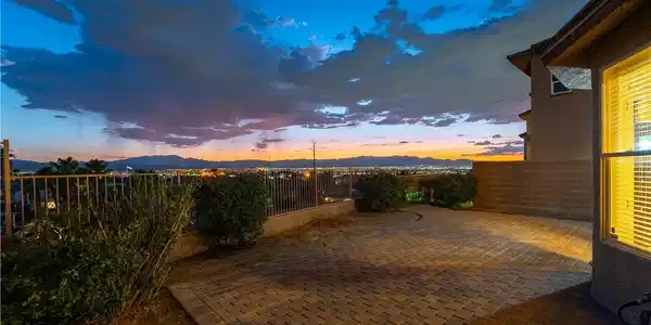 Image 3: City lights twinkle beyond this paver patio, offer