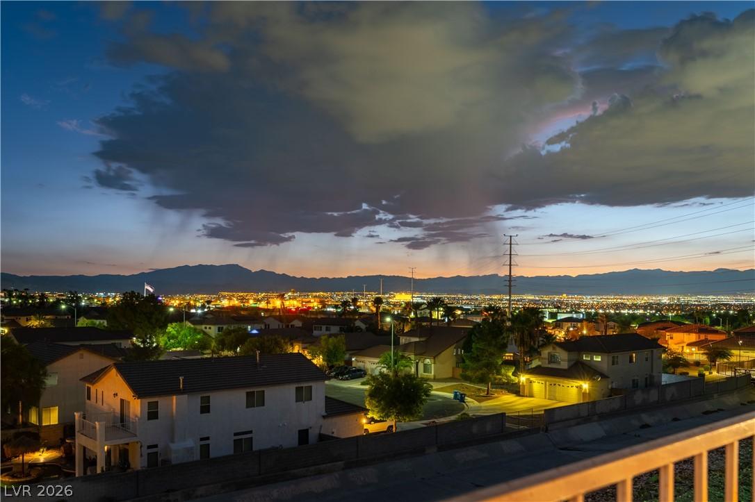 Image 4: City lights illuminate the valley against a dramat