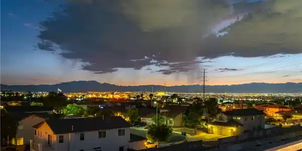 Image 4: City lights illuminate the valley against a dramat