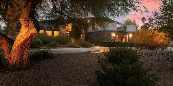 Image 4: Dramatic exterior lighting illuminates the stone a