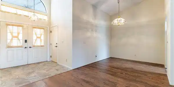 Image 3: A spacious dining area with vaulted ceilings and w