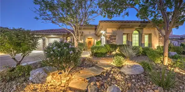 Image 3: Lush desert landscaping and a flagstone path creat