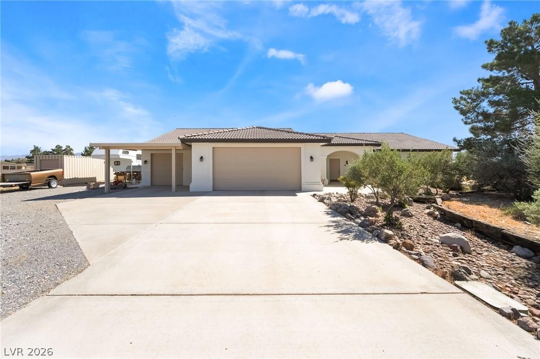 Image 1: This ranch-style home features a spacious driveway