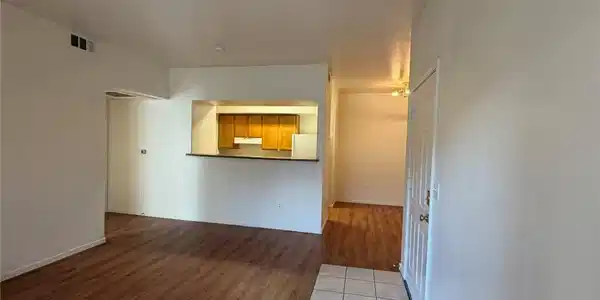 Image 4: Warm wood flooring meets tiled entryways in this o