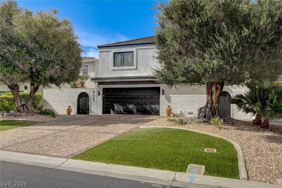 Image 2: This contemporary home features an inviting drivew