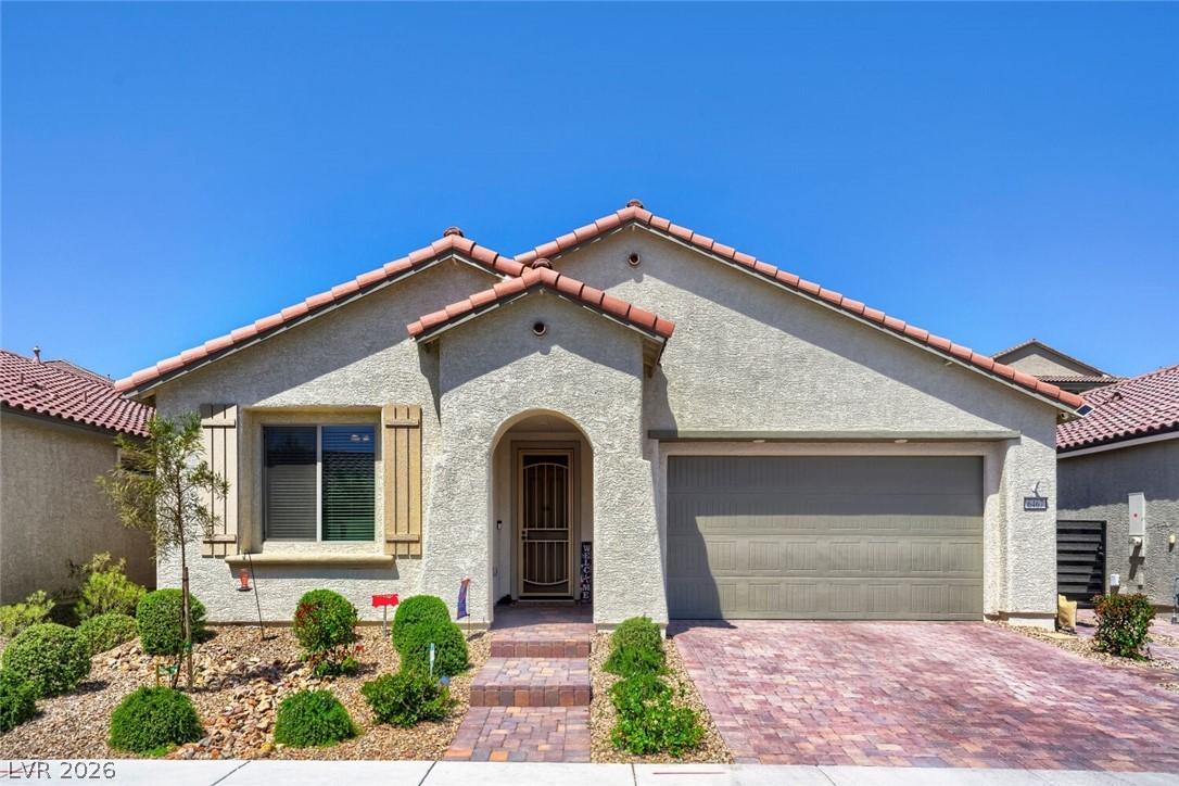 Image 2: This appealing stucco home features a tiled roof a