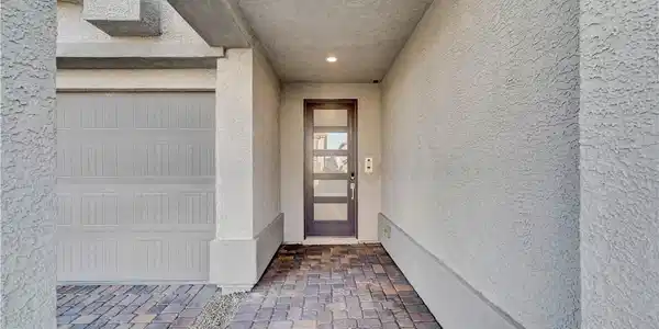 Image 2: A recessed entryway features textured stucco walls