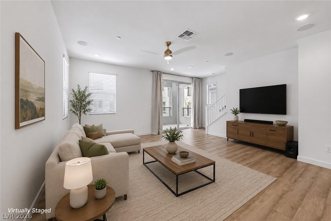 Image 3: A generous living area presents warm wood flooring