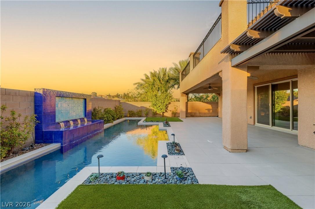 Image 4: An inviting backyard oasis offers a serene pool wi