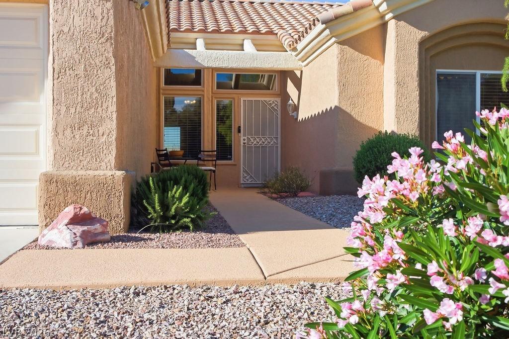 Image 2: View of exterior entry with stucco siding and a ti