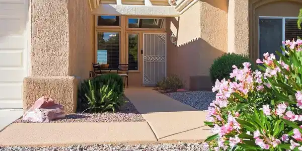 Image 2: View of exterior entry with stucco siding and a ti