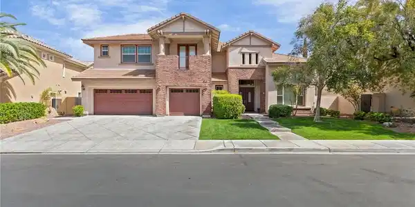 Image 2: A striking stucco and brick residence features a w