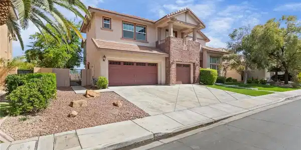 Image 3: Two-story home features a tiled roof, two garage b