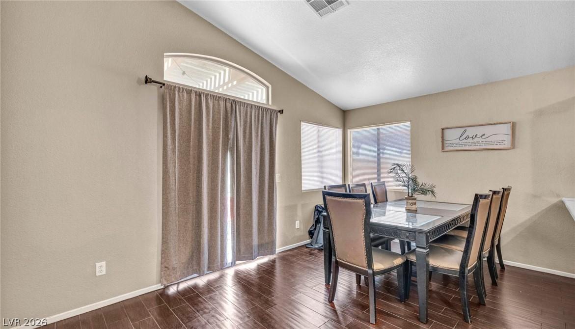Image 4: This dining area features rich wood flooring, vaul