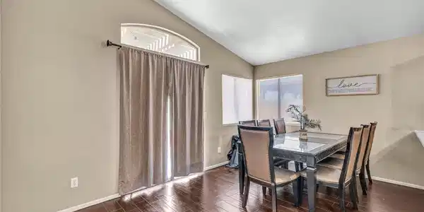 Image 4: This dining area features rich wood flooring, vaul