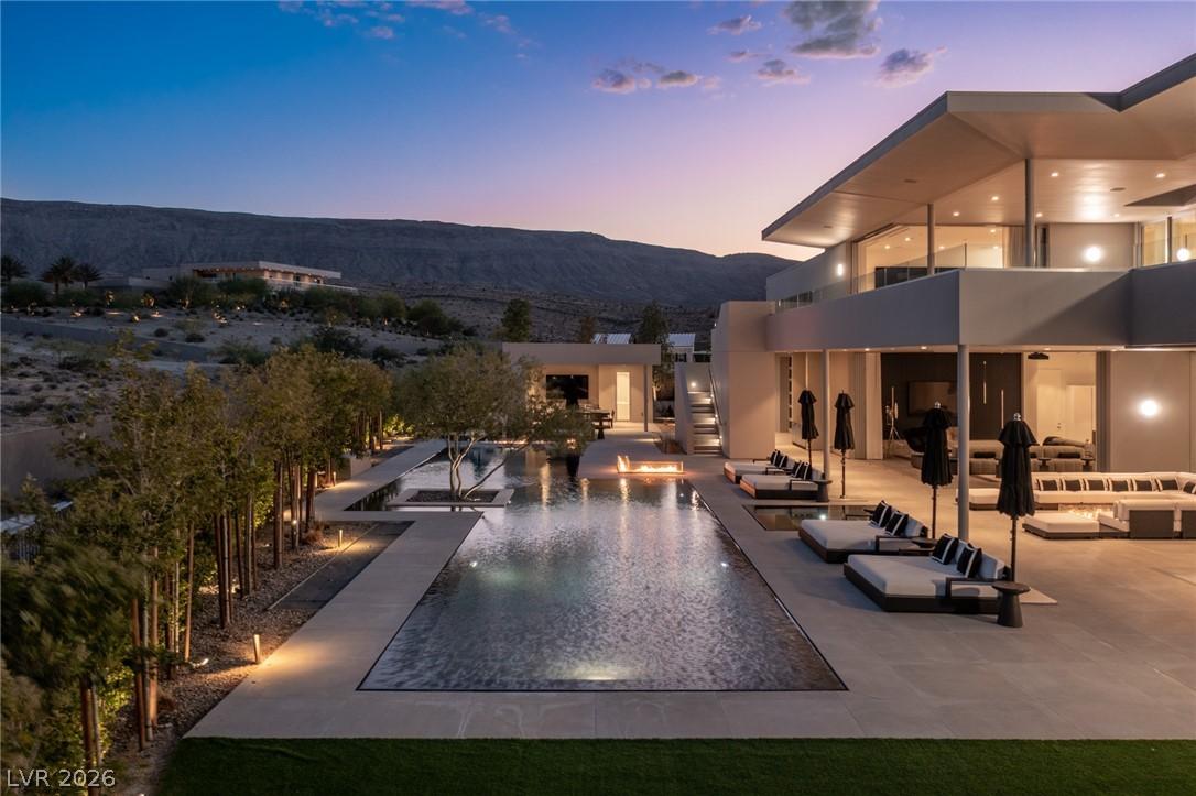 Image 3: An illuminated desert oasis features a long swimmi