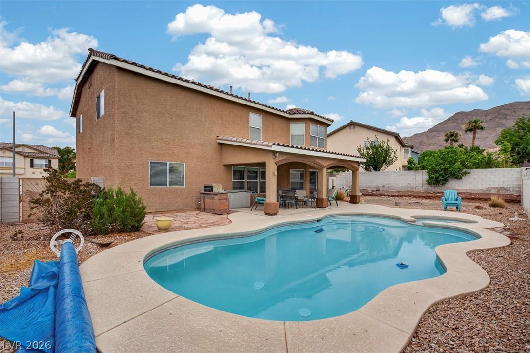 Image 2: An inviting backyard oasis offers a freeform pool