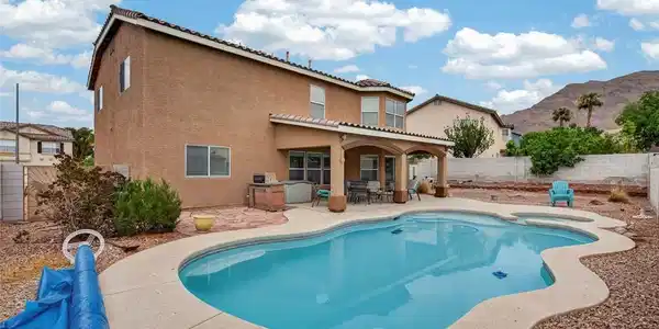 Image 2: An inviting backyard oasis offers a freeform pool