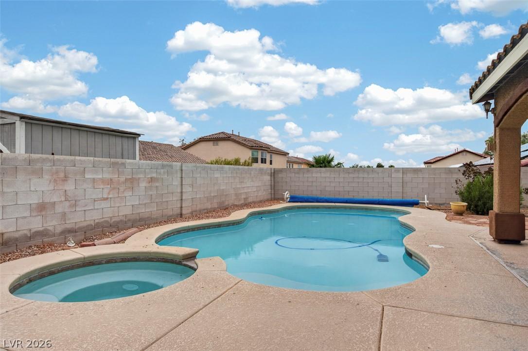 Image 3: An inviting in-ground pool with an integrated spa