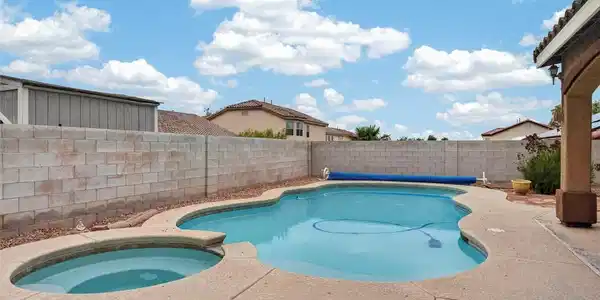 Image 3: An inviting in-ground pool with an integrated spa