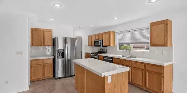 Image 4: A well-equipped culinary space boasts ample cabine