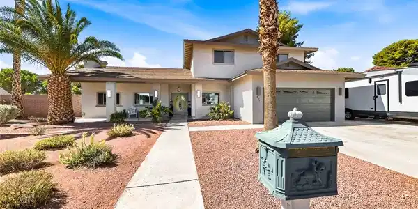Image 2: A well-maintained stucco home with an attached gar