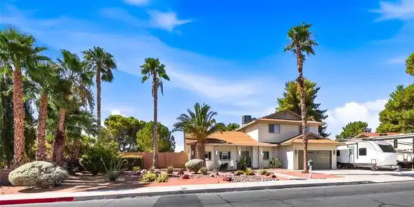 Image 3: Mature palm trees and desert landscaping adorn thi