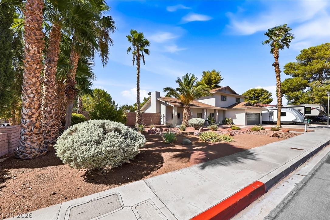 Image 4: Mature palm trees and xeriscaping provide a welcom