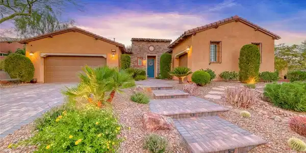 Image 2: Desert landscaping and a paved walkway lead to thi