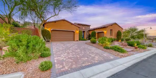 Image 3: A handsome paver driveway leads to this stone-acce