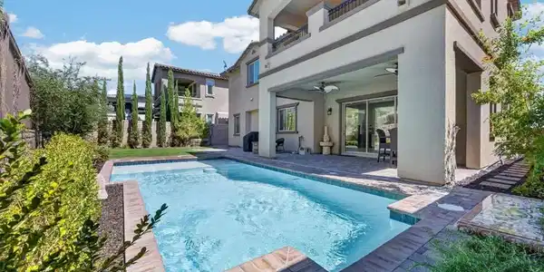 Image 2: An inviting backyard oasis features a sparkling sw