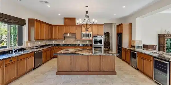 Image 4: Rich maple cabinetry and expansive volcano granite