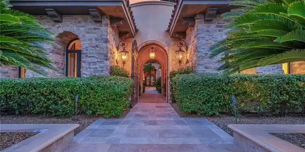 Image 2: An arched stone entryway leads into a private cour