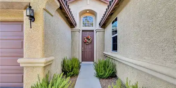 Image 4: A welcoming entry features a dark wood door with a
