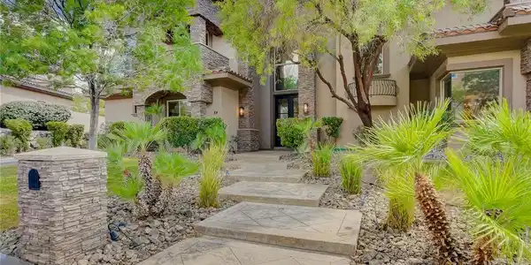 Image 4: A patterned concrete walkway leads past desert lan