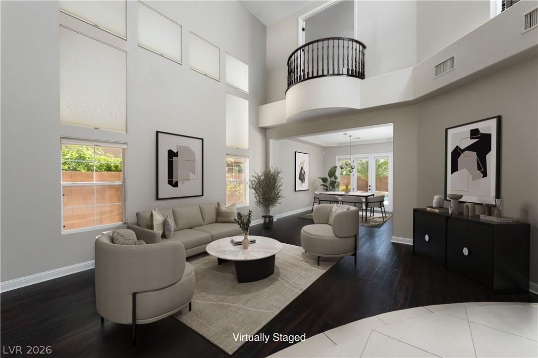 Image 4: A spacious living room features soaring ceilings,