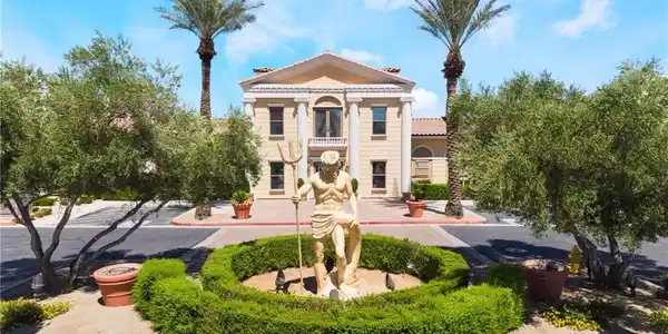 Image 2: Grand estate entry features a statue amidst manicu