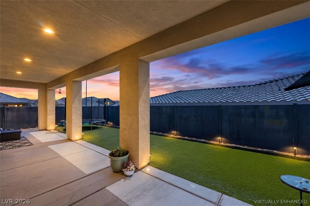 Image 4: A spacious covered patio invites relaxation, overl