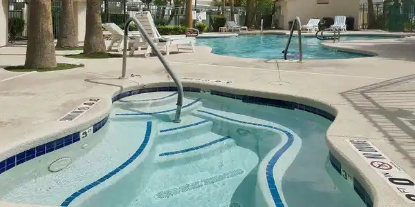 Image 3: A sparkling in-ground spa sits adjacent to the com