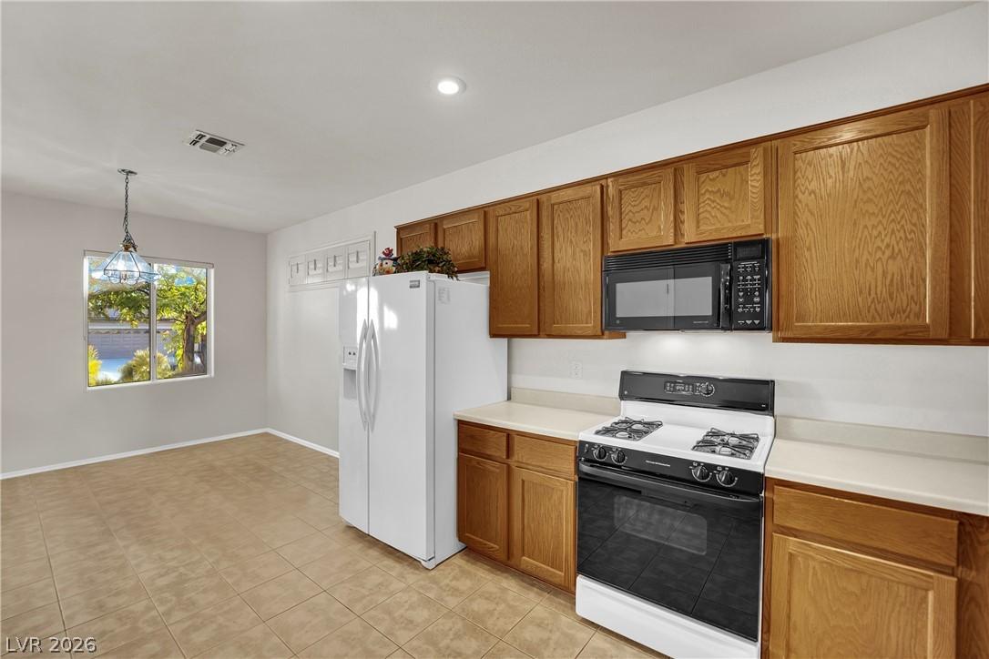 Image 4: A well-equipped kitchen features tile flooring and