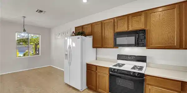 Image 4: A well-equipped kitchen features tile flooring and