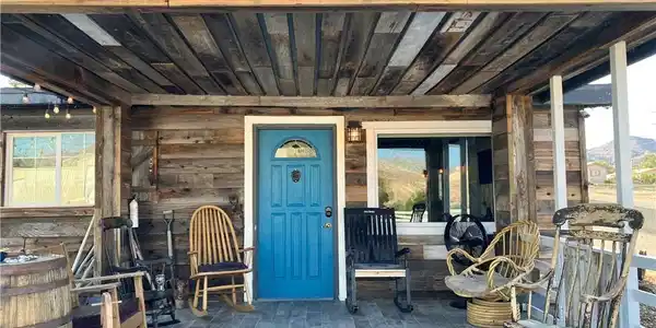 Image 2: A welcoming wooden porch with a bright blue entry