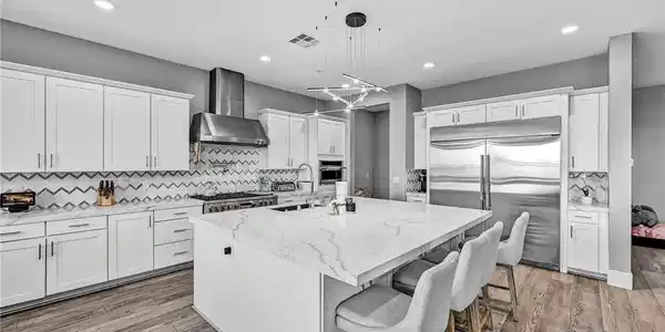 Image 3: A well-appointed kitchen features a spacious islan