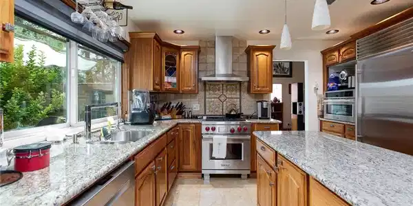 Image 2: A gourmet kitchen boasts granite counters, ample c