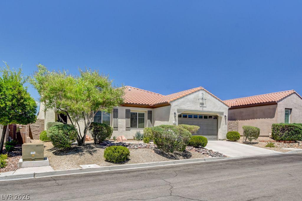 Image 3: A well-maintained stucco home with a tile roof and