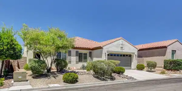 Image 3: A well-maintained stucco home with a tile roof and