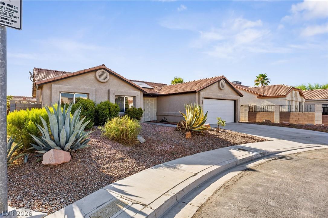 Image 3: A well-maintained stucco home with a tile roof and