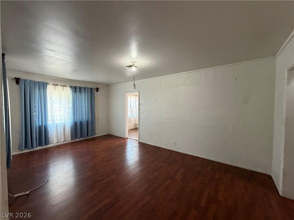 Image 3: Rich wood flooring grounds this airy living space,