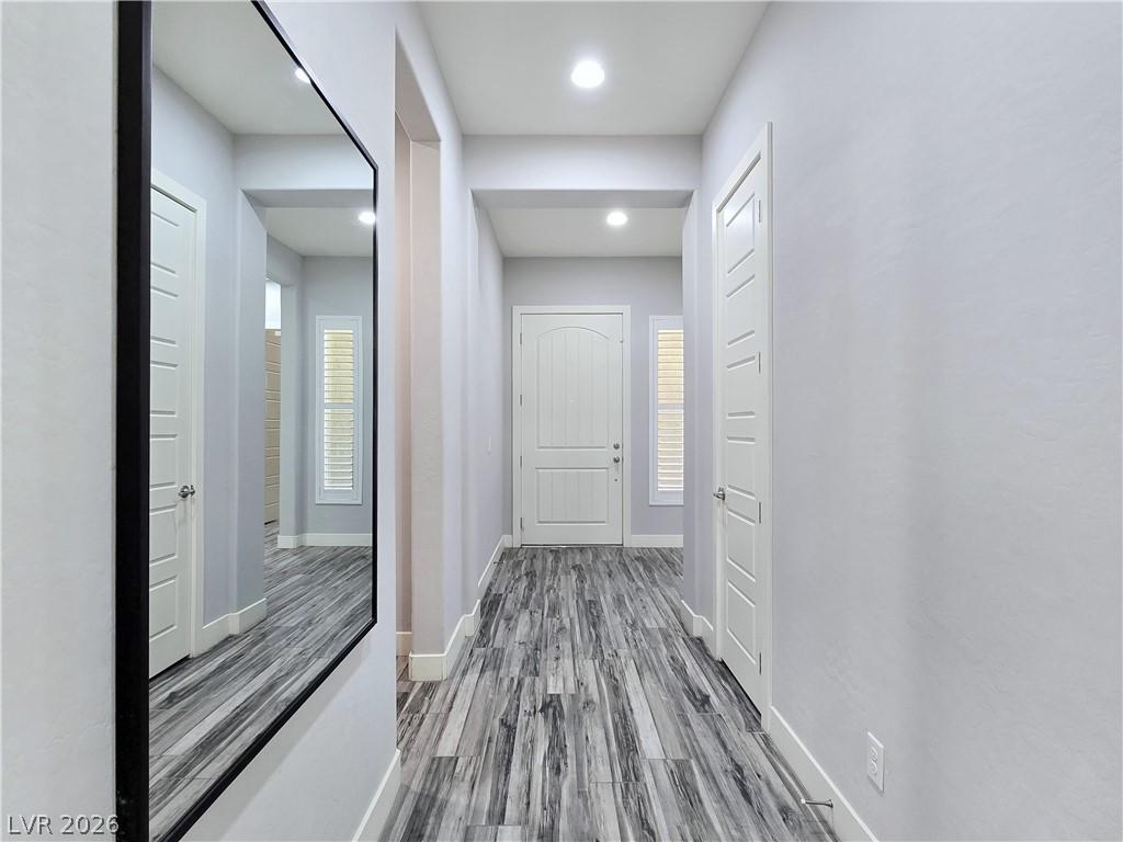 Image 3: A well-lit hallway featuring sleek wood-look tile