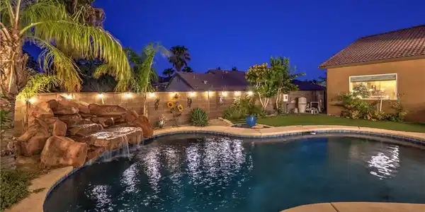 Image 2: A tranquil backyard oasis features a rock waterfal